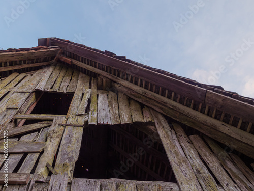 Weathered Wooden Barn Facade With Broken Planks And Sky