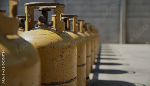 Canvastavla A long row of aged, yellow propane gas cylinders lined up neatly on a concrete surface, casting long shadows in the daylight