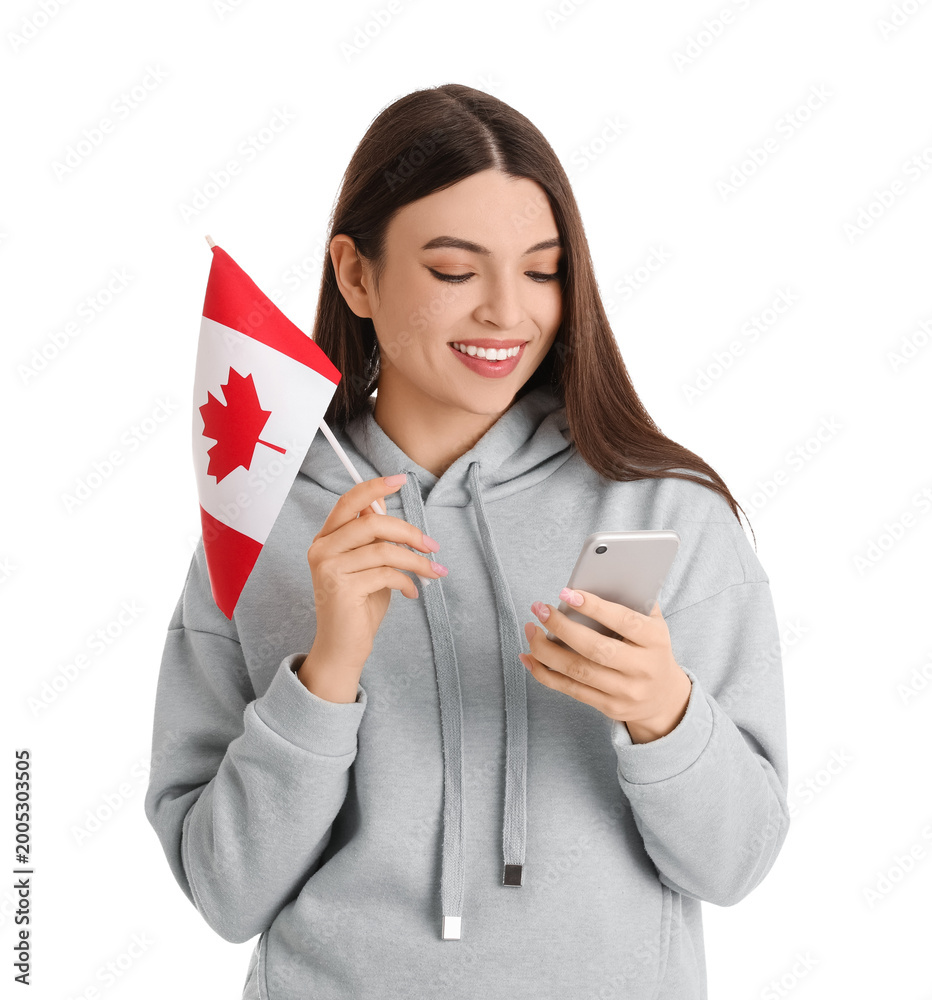 Naklejka premium Young woman with flag of Canada using mobile phone on white background