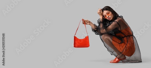 Beautiful young woman holdi...