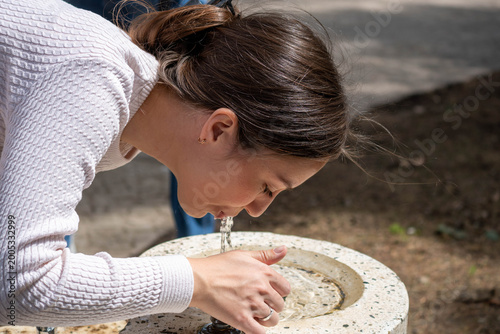 Konstfotografi woman drinking from street fountain