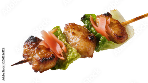 Grilled chicken yakitori skewer with ginger and lettuce garnish