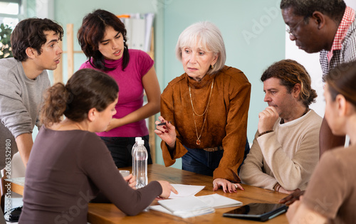 Photos Focused men and women of different ages actively communicating and sharing ideas