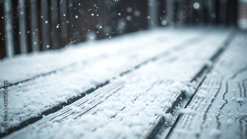 Snow-covered wooden surface with falling snowflakes, evoking a serene winter atmosphere.