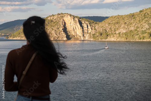 Obraz na plátně Una mujer observa un barco navegando en el pantano de Entrepeñas, Guadalajara, España
