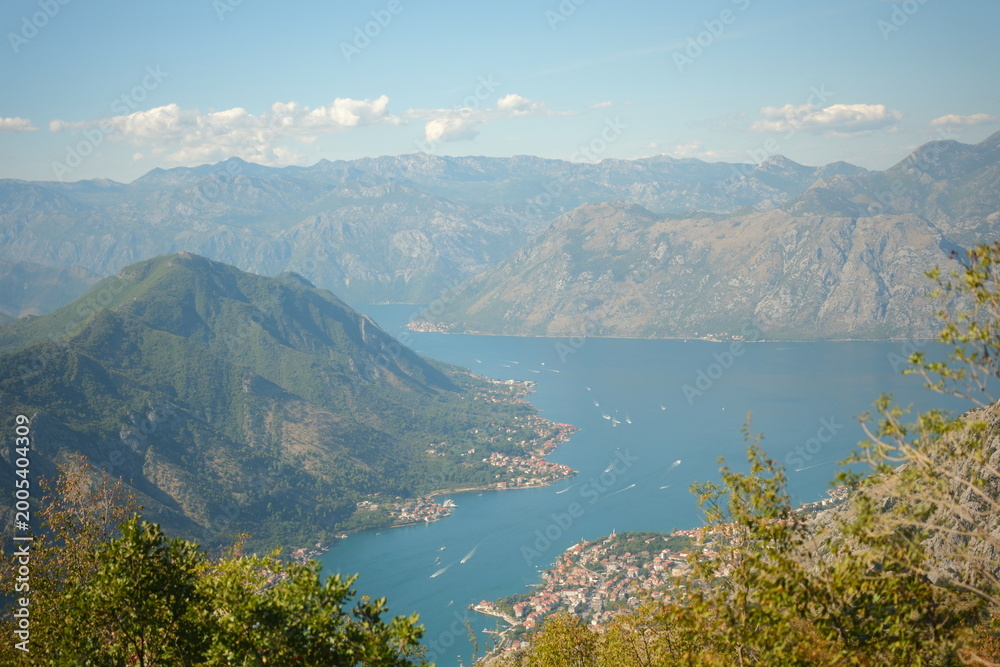 Fototapeta premium Panoramic view of the Bay of Kotor (Boka Kotorska) in Montenegro. Scenic coastal landscape with deep blue sea, majestic mountains, and a small town at the foot of the cliffs.