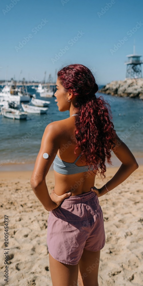 Fototapeta premium Young woman standing at marina looking out over boats