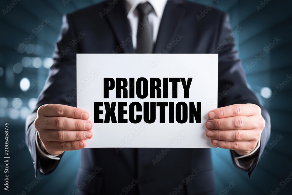 Obraz premium Man in Suit Showing a Priority Execution Sign