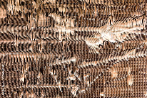 Close-up of damaged copper cooling fins of an outdoor air conditioner unit.