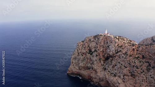 Flying around Lonely Lighthouse at Cap de Formentor with breathtaking Mediterranean seascape. Majorca Island, Balearic Islands, Spain. Aerial drone point 4K video shot.