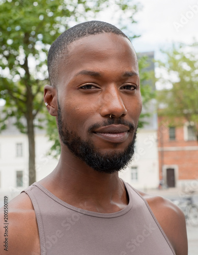 A calm portrait of a transgender Somali female in northern Europe Scandinavia showing her pride and identity on a city street.