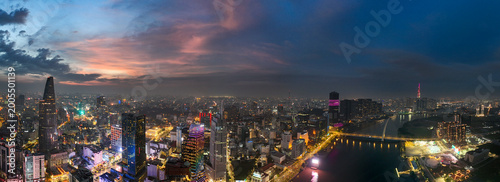 Vast panoramic night view of Ho Chi Minh City skyline at sunset with illuminated skyscrapers and the Saigon River