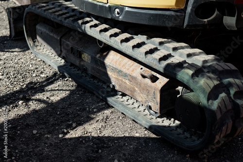 Durable mechanical tread system on a construction vehicle parked on rocky ground, illustrating fleet maintenance, building logistics and earthmoving hardware