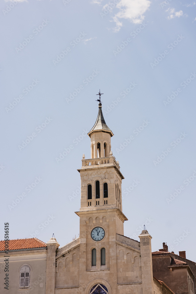 Fototapeta premium Tall stone bell tower with a clock