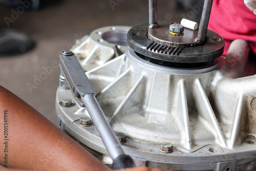 Quadro su tela ​A professional technician uses a precision torque wrench to tighten bolts on a heavy-duty aluminum transmission casing during a mechanical assembly process