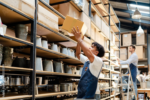 Obraz na plátne warehouse worker arrange brown paper box container checking inventory in store r