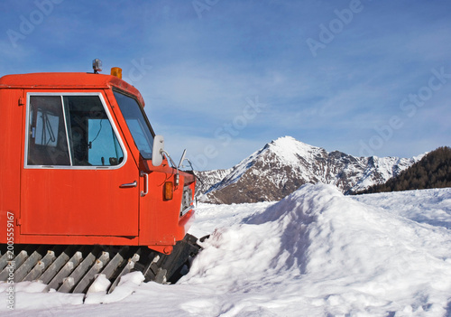 Fotografija tracked snowplough parked in front of piled snow