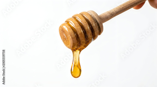 Wooden honey dipper with dripping honey on white background
