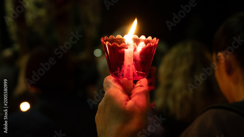 Foto Crowd of believers holding lit candles in red cups during Orthodox Easter midnight service in Greece, celebrating the Resurrection in a spiritual night ceremony