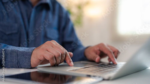 Close-up A Businessman typing laptop computer communicates on internet technology on office desk. Workplace, Businessman professional working on new job project. Business technology concept.