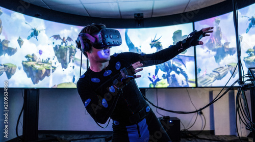 Man exploring virtual reality dragon world in motion capture suit
