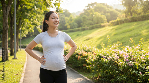 Beautiful young Asian pregnant woman doing morning jogging exercise, posing with nature background. 