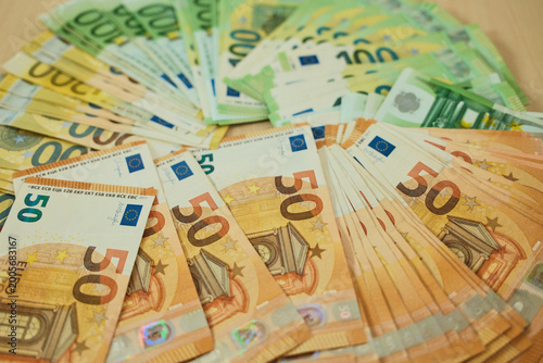 Billede på lærred Euro banknotes are arranged in grouped stacks by denomination on a wooden surface