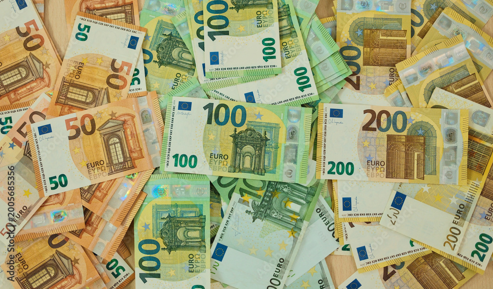 Obraz premium Euro banknotes are arranged in grouped stacks by denomination on a wooden surface. Cash savings and wealth concept for finance, budgeting, investment and banking use.