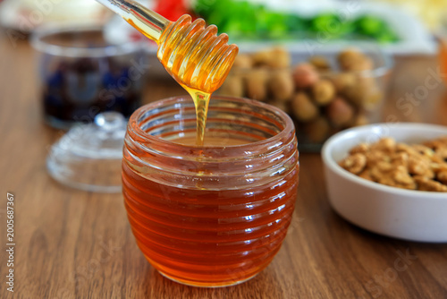  honey dripping from wooden dipper