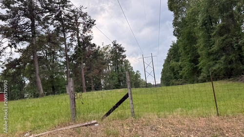 A fenced in field by a power line corridor during springtime