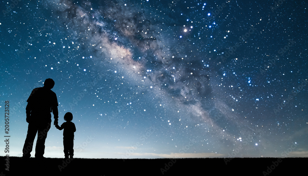 Fototapeta premium 星空を見上げる親子のシルエットのイメージ画像