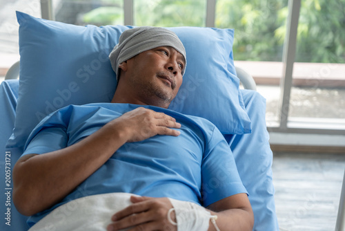 Fotografie Asian male cancer patient on bed with an IV drip stress and sadness reflecting the emotional burden of illness
