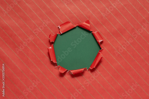 Torn red wrapping paper revealing a green background
