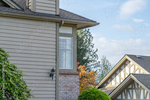 Suburban house exterior with gabled roof and window in quiet neighborhood