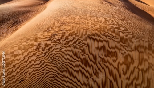 wavy sand dune texture background top down desert view showing natural ripple warm light shadow ideal nature solitude or travel theme custom desert tan background