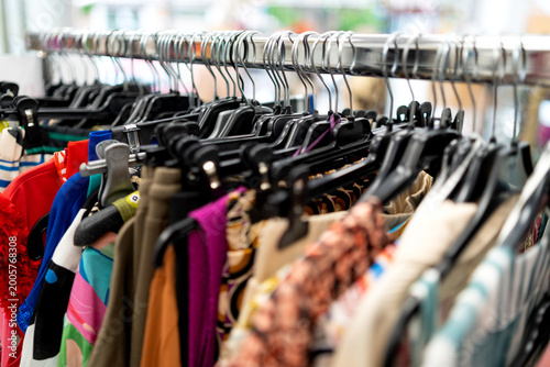 Clothes rack with fashion items and hangers in a retail clothing store