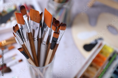 Photography Paint brushes, paints and palette on light grey table, closeup