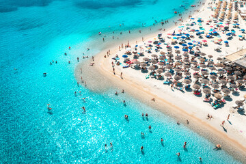 Keuken achterwand Turquoise Aerial view of colorful umbrellas on white sandy beach, swimming people in blue sea on sunny summer day. Sardinia, Italy. Tropical landscape with clear azure water. Summer travel. Top view of ocean  © den-belitsky