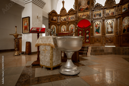 Foto Orthodox baptismal font and iconostasis in church interior for christian christe