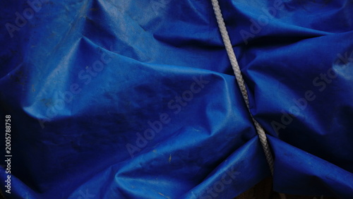 blue tarpaulin waving and white rope as a background