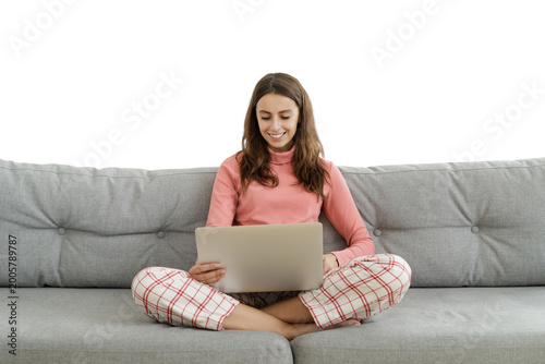 Portrait of young lady relaxing in living room watching videos or chatting on laptop she is holding