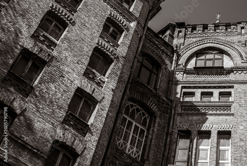 Dramatic monochrome facade with decorative corbelled arch and patterned cornice