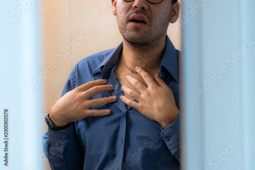 Slika na platnu Man touching his neck scar with visible stitches in front of mirror