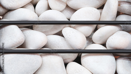 Bild auf Leinwand Smooth white stones fill a container, separated by thin black bars
