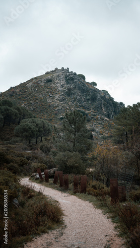 Fotografia Gravel hiking trail winding toward a rocky peak in the Sierra Norte mountains near Seville