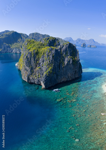 Dramatic limestone islands rise in Bacuit Bay, El Nido. This scenic area in the Philippines is a popular vacation destination due to its beautiful coral reefs, beaches, and hidden lagoons.