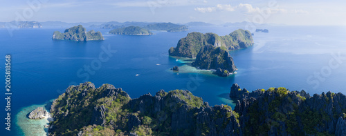 Dramatic limestone islands rise in Bacuit Bay, El Nido. This scenic area in the Philippines is a popular vacation destination due to its beautiful coral reefs, beaches, and hidden lagoons.