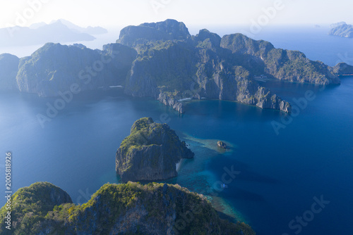 Dramatic limestone islands rise in Bacuit Bay, El Nido. This scenic area in the Philippines is a popular vacation destination due to its beautiful coral reefs, beaches, and hidden lagoons.