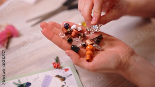 Close-up of female hands opening a bag of beads and details to create handmade jewelry. Craftswoman creating unique custom accessories in creative workshop. Handcrafted DIY jewelry artwork concept.