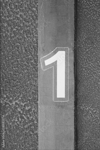 Number one on industrial concrete column, black and white minimalist photo